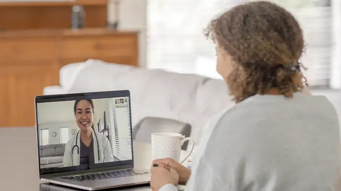Person watching a healthcare provider on a laptop.