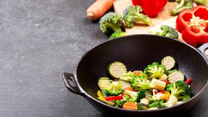 Chicken and vegetable stir fry chopped in a black wok