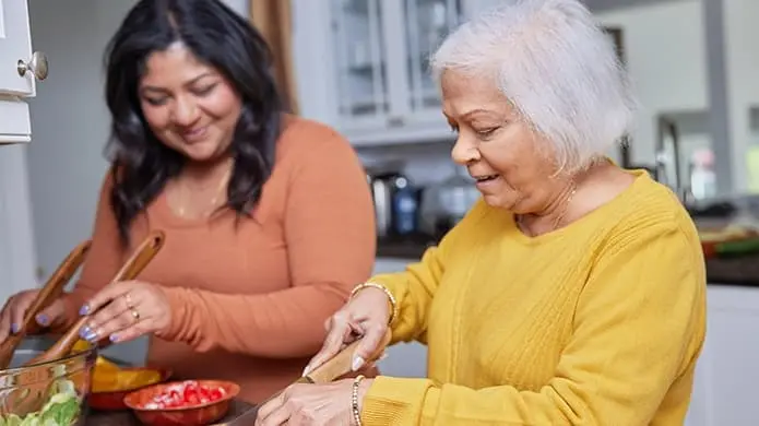 Two women making a salad in a kitchen