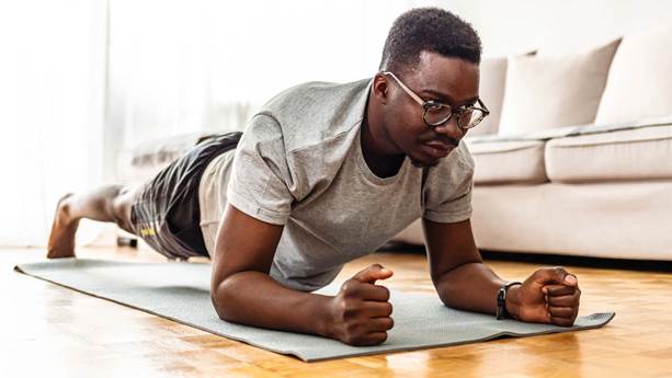 A man doing the plank exercise on a mat at home.