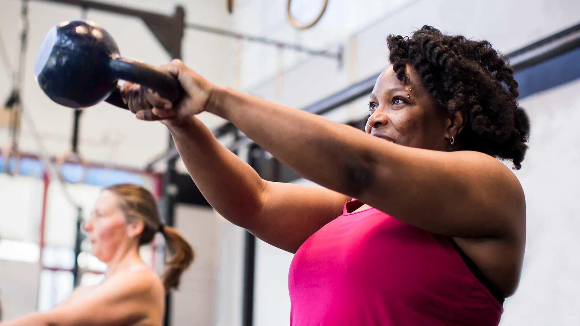Group of people working out with kettlebells while keeping distance between them.