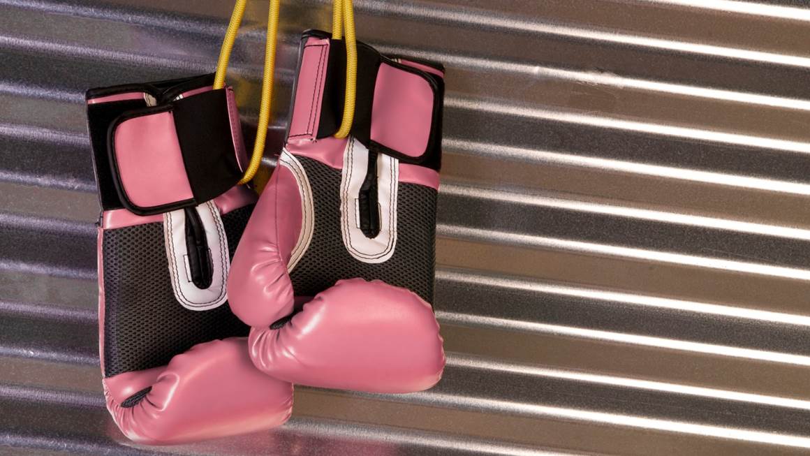 Pink boxing gloves hanging on hook
