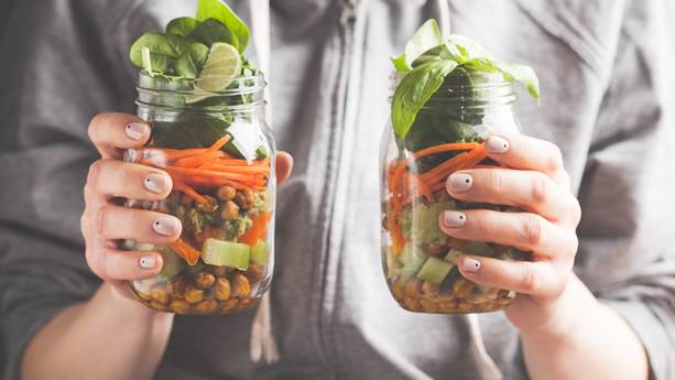 Woman holding up salad jars