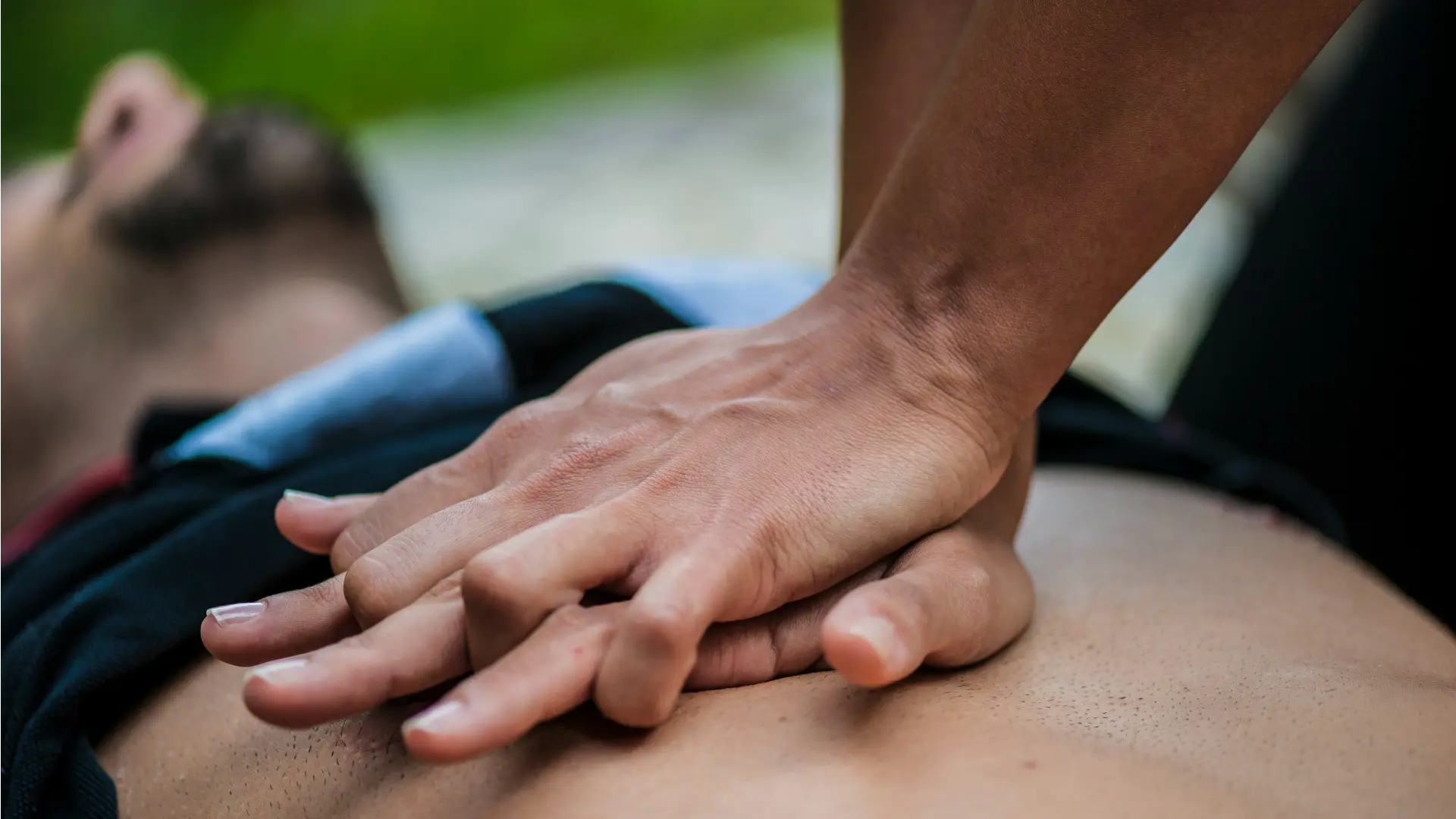 A person performs chest compressions on someone in cardiac arrest.
