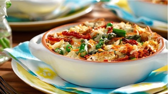 Breakfast strata primavera served in a white baking dish on top of a blue yellow and white napkin on