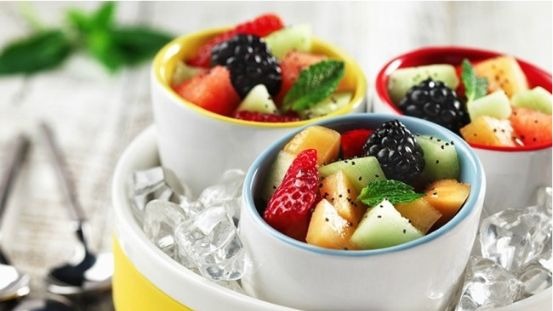 Three ramekins with diced melon, strawberries and berries