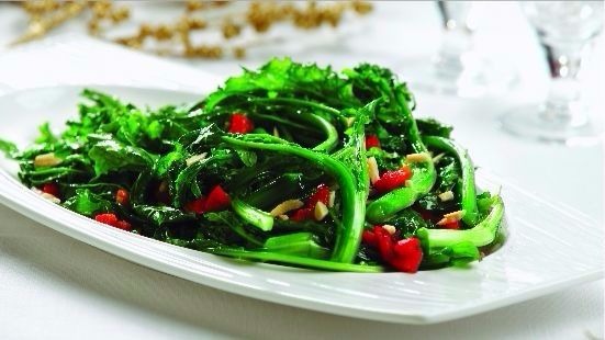 Holiday rapini saut served on a white plate on a white table cloth