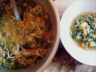 Bowl of Ramen noodles, broth, carrots, kale 