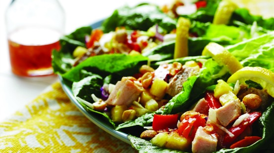 Chopped chicken, roasted red peppers, chopped pineapple and peanuts on a lettuce leaf 