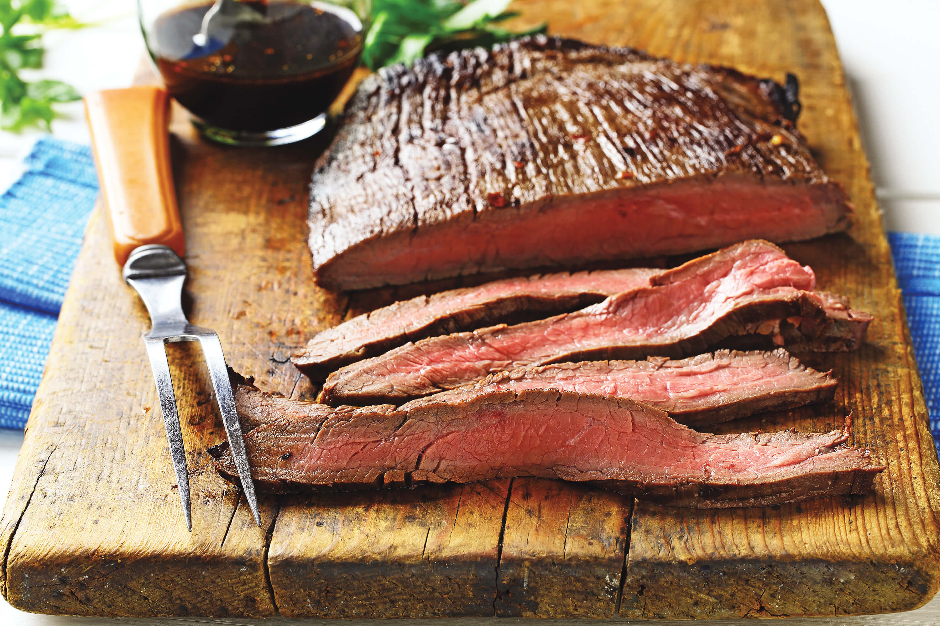 Sliced flank steak on wooden cutting board