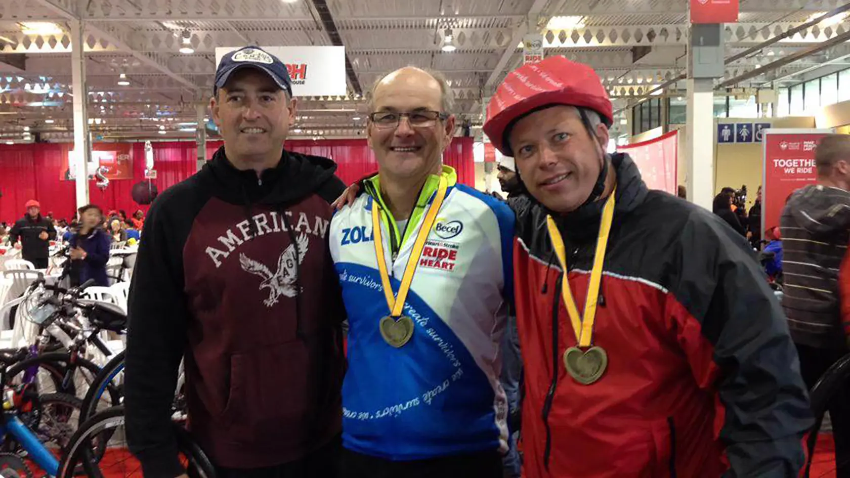 Three men smile together.