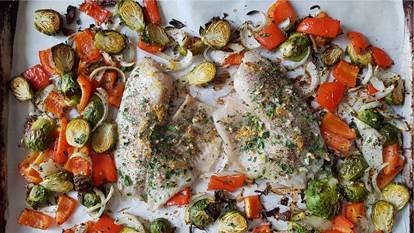 tilapia fillets, brussel sprouts, red peppers on parchment paper