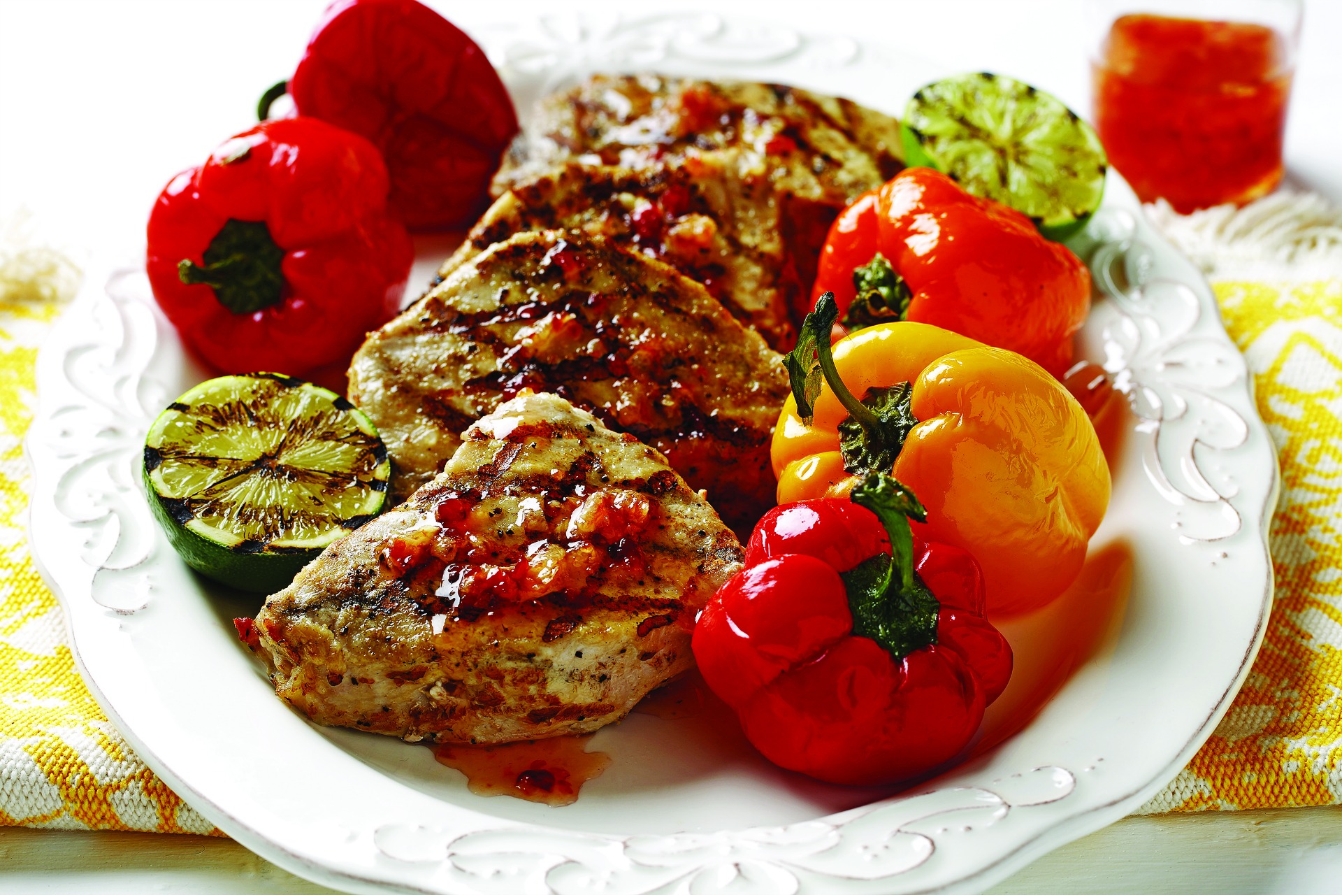 plate of pork with petite peppers, grilled zucchini and fresh ginger hot sauce