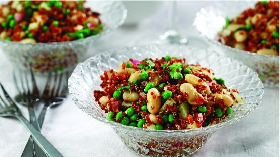 Glass bowls filled with quinoa, cannellini beans, peas and cilantro