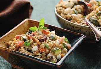 Mediterranean salad with roasted vegetables and whole wheat couscous in a square bowl.