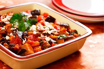 Roasted eggplant, tomatoes and feta cheese in casserole dish 