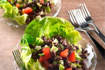 Lime-zested tomatillo-black bean salad on lettuce leaves.