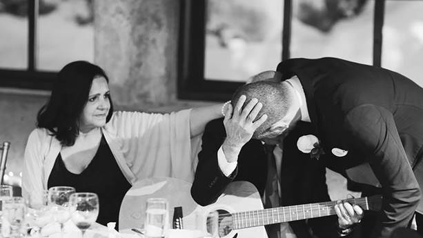 At this wedding, Regis gives his father Pedro an emotional hug after Pedro plays guitar and sings while recovering from a stroke.  