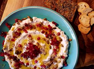 Ricotta and yogurt spread topped with pomegranate, pumpkin seeds and olive oil 