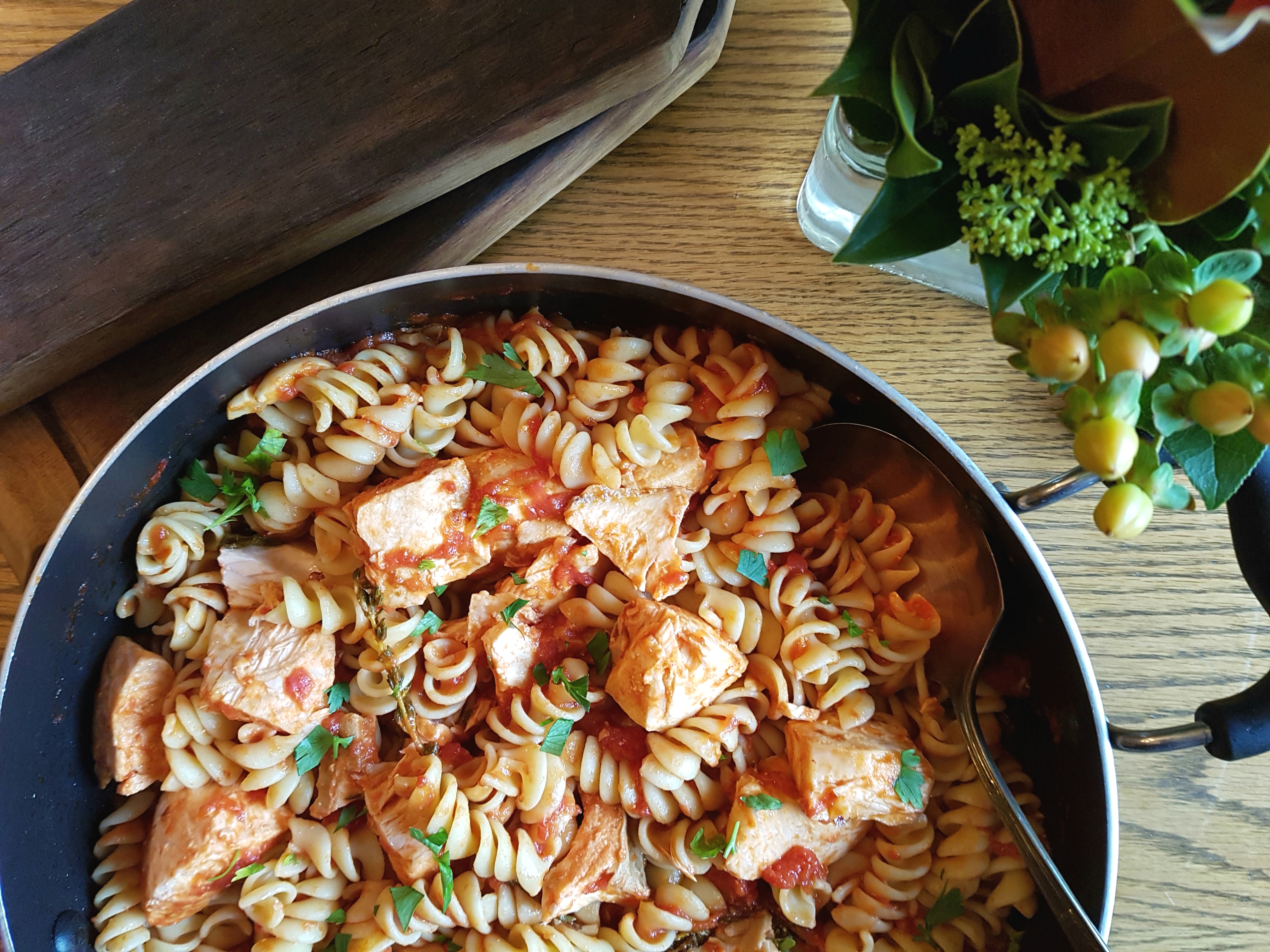 Cooked salmon, fusilli pasta, herbs in skillet 