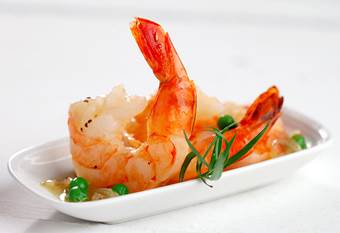 Cooked shrimp and peas served on white plate 