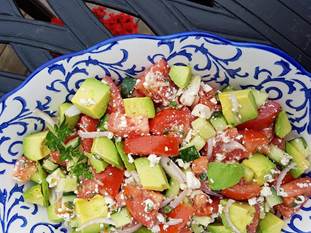 Chopped tomatoes, avocado and feta on blue and white plate