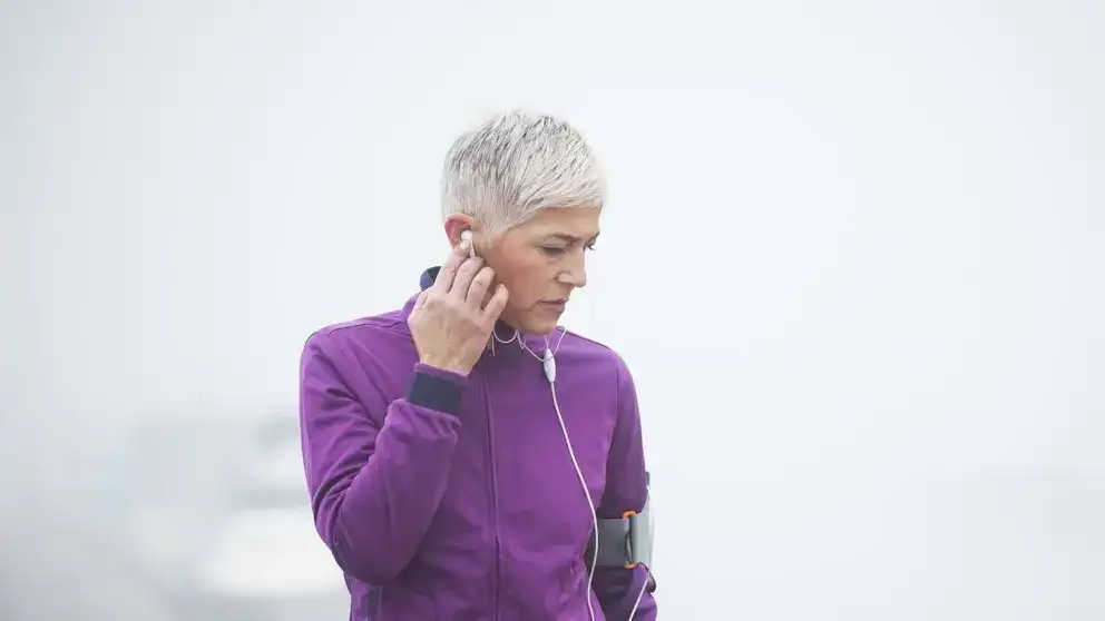 Woman listening to music while exercising outside 