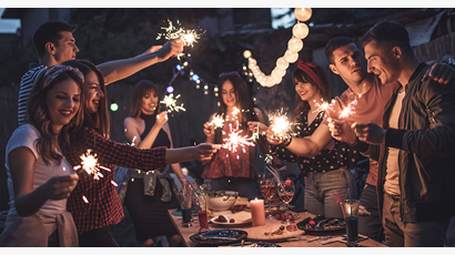 A group of people celebrating with sparklers at night.