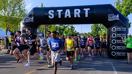 A group of runners taking off at the start line of the marathon.