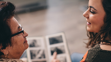 Grandmother and grandaughter talking, looking at photo album