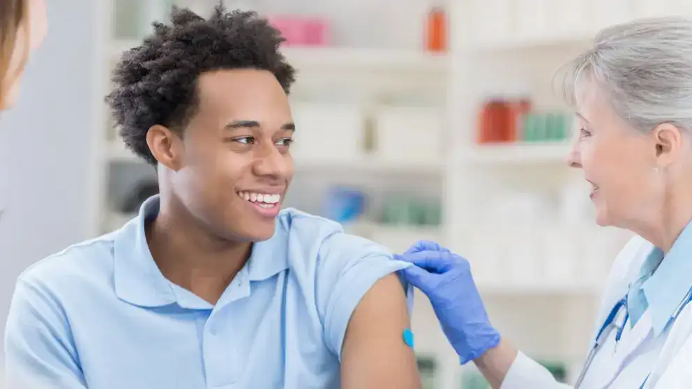 Health worker administers a flu shot to a person.