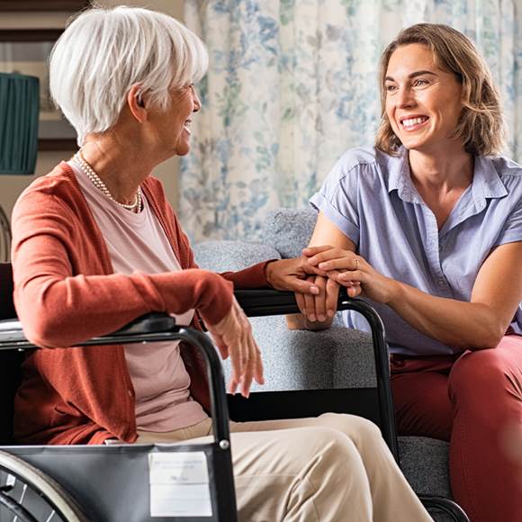 A woman talking to a senior person on a wheelchair