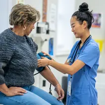 A nurse checks a patient’s blood pressure.