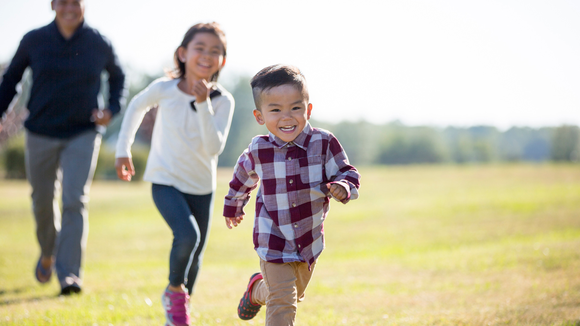 young boy girl and father running outside