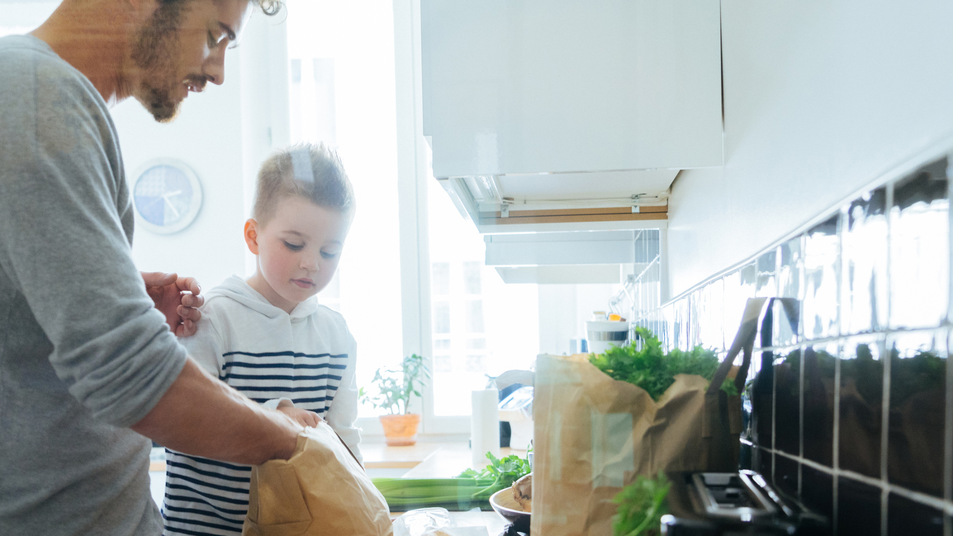 Father and son organizing groceries in the kitchen