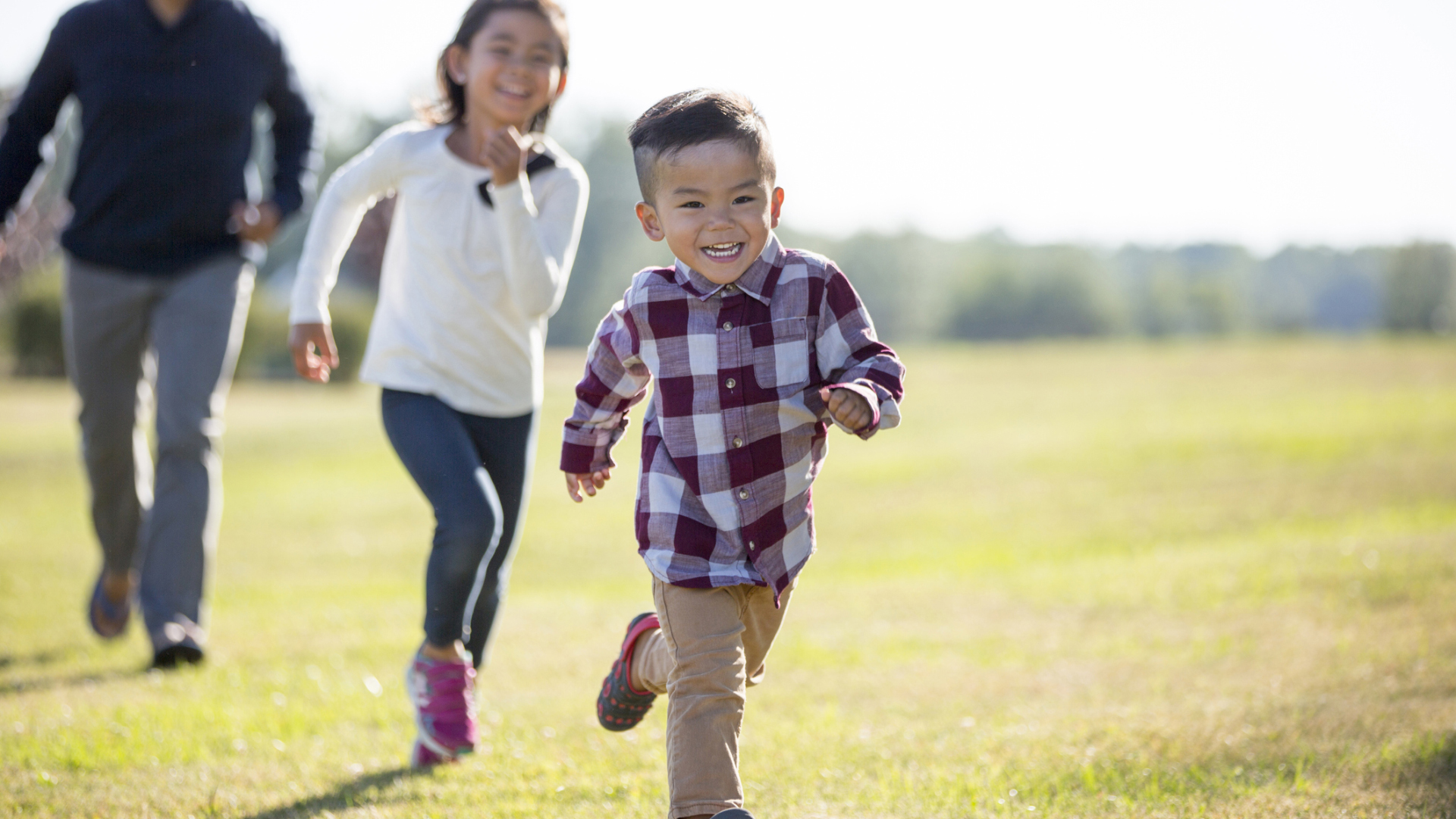 Young boy girl and father running outside
