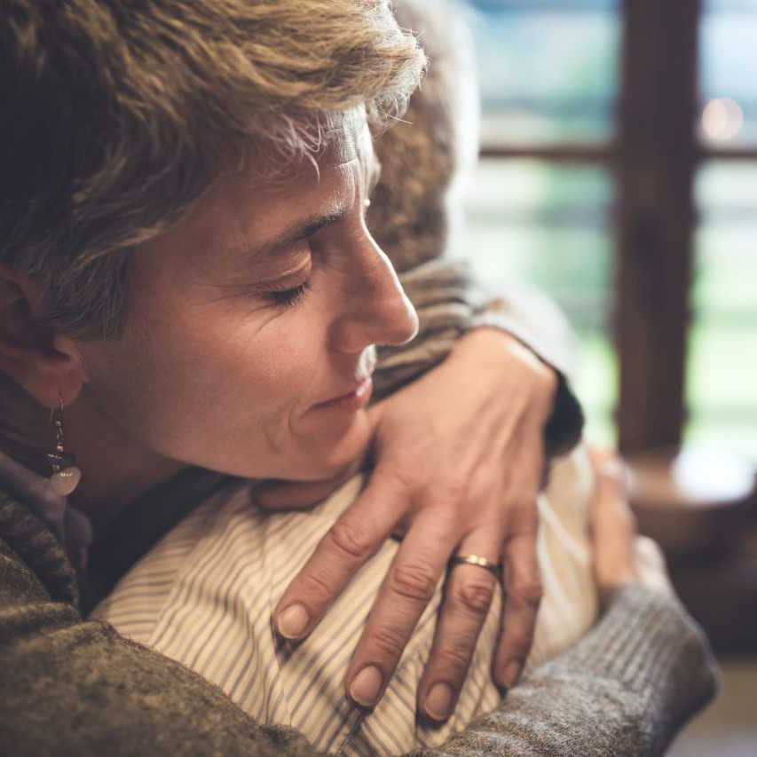 Woman hugging someone with her eyes closed