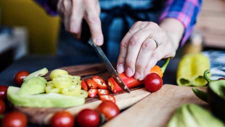 Woman cutting a chili pepper up close