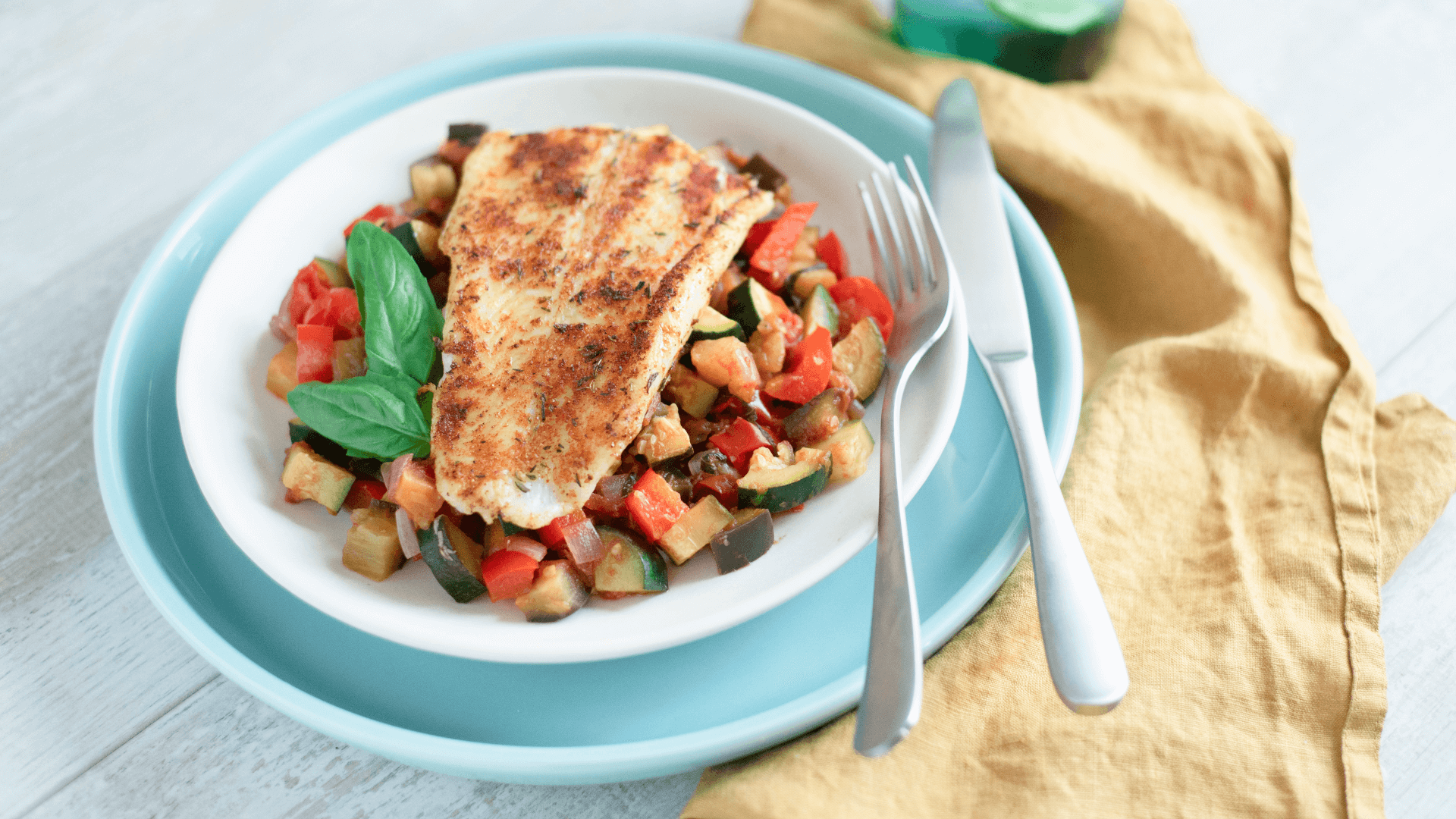 A basa fillet on top of a bed of ratatouille