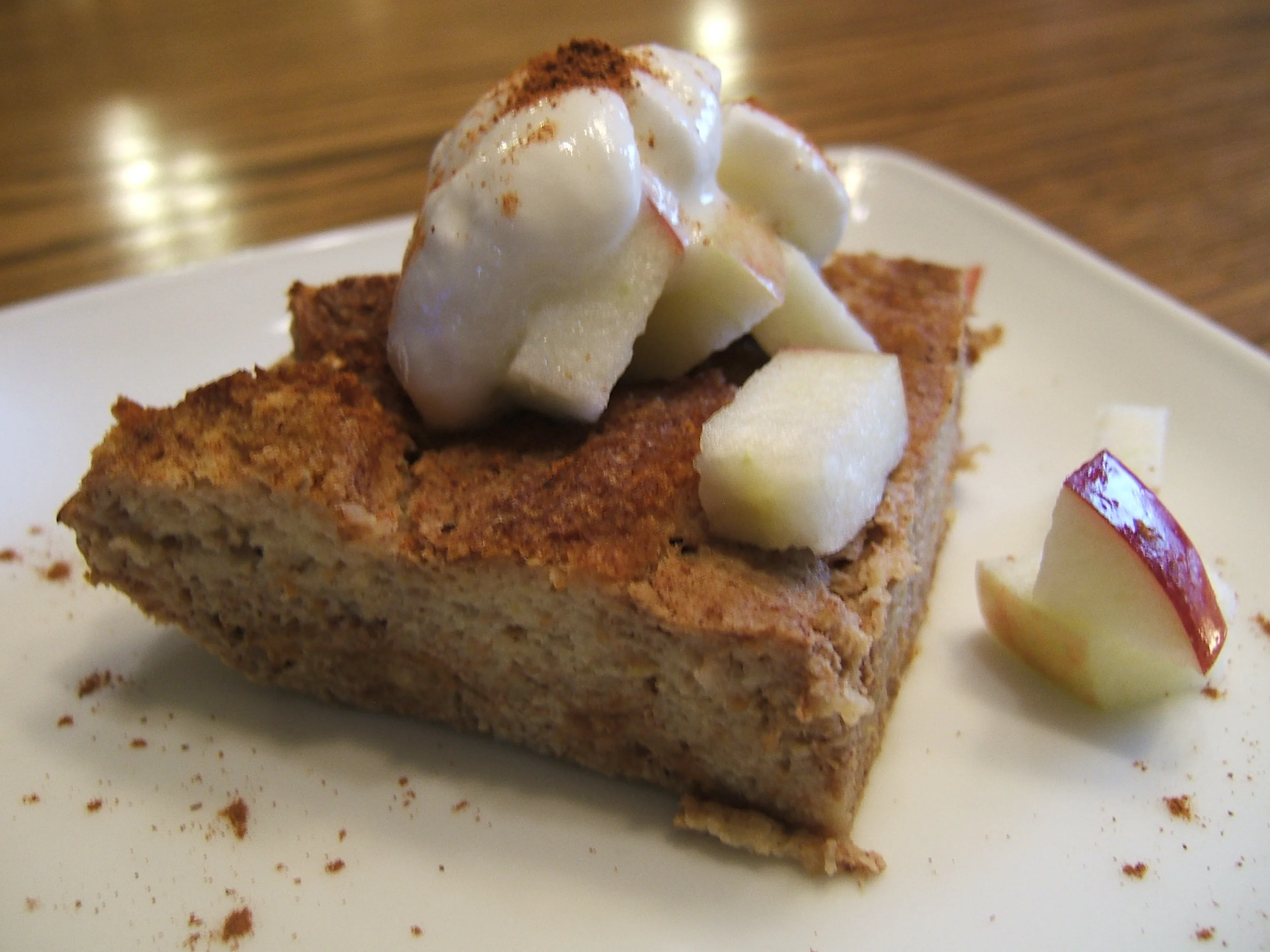 A slice of cinnamon apple bread pudding with apple on top.