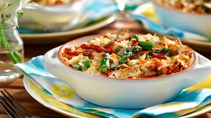 Breakfast strata primavera served in a white baking dish on top of a blue yellow and white napkin on