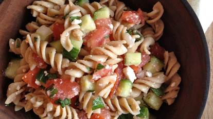 Chunky cucumber and tomato gazpacho pasta salad in a wooden bowl