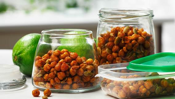  Two glass jars filled with crispy chickpeas, lime in background.
