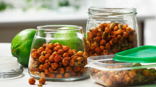 crispy chickpeas and pumpkin seeds in two glass jars with limes in background 