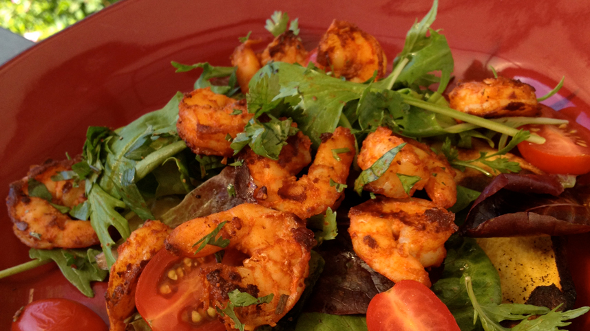 Grilled tortilla and shrimp salad in a red bowl