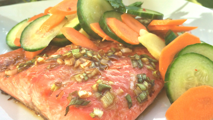 Rainbow trout with ginger carrot and cucumber on a white plate