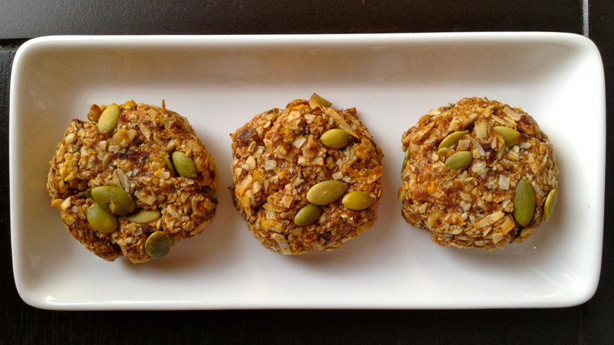 Three Orange coconut cookies on a white rectangle plate