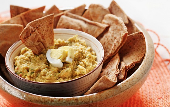 protein powered hummus with hard boiled egg in bowl with whole wheat pita bread