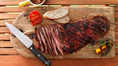 Yucatan spiced skirt steak on a wooden board with a knife
