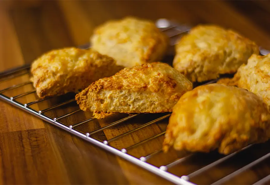 Cheese scone wedges on a grilling tray on a table